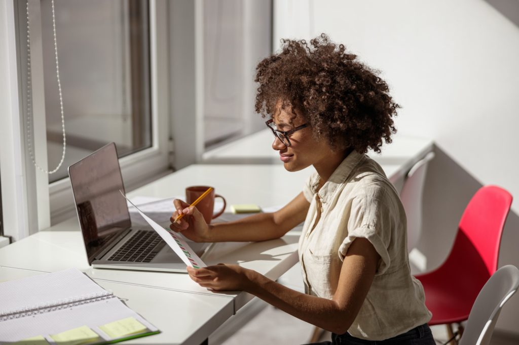 Young Afro American lady looking at the report in the office